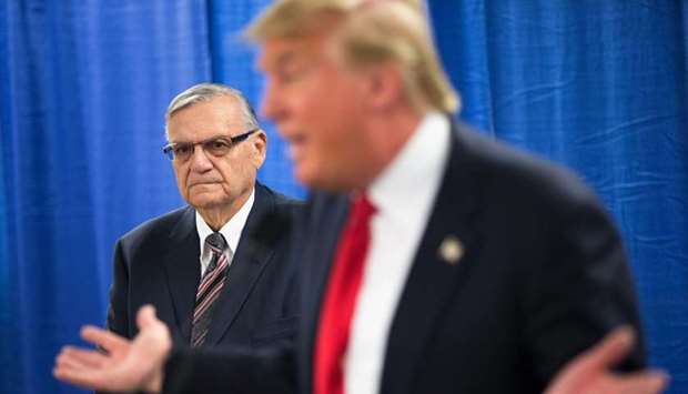 This file photo taken on January 25, 2016, shows Sheriff Joe Arpaio listening as Republican presidential candidate Donald Trump speaks to the press prior to a rally in Marshalltown, Iowa.