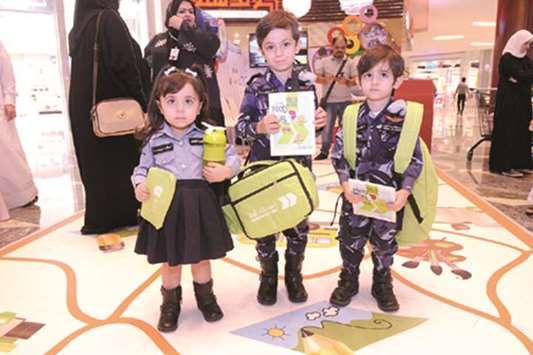 Young students showing their school bags, lunch boxes, water bottles, pencil cases and food information cards from the WCM-Qu2019s initiative.