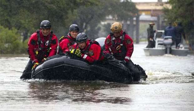 Houston Fire Department dive team members motor through high water on North Braeswood Boulevard looking for flood victims in Houston, Texas on Monday.
