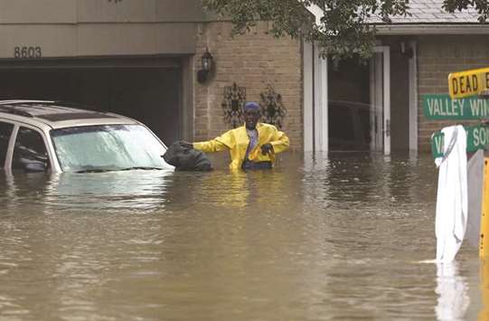 People wait to be rescued from their flooded homes after the area was inundated with flooding from Hurricane Harvey yesterday in Houston, Texas.