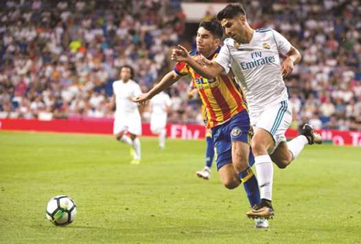 Valenciau2019s Alvaro Medran (left) vies for the ball with Real Madridu2019s Marco Asensio during the Spanish La Liga match at the Santiago Bernabeu stadium in Madrid on Sunday night. (AFP)