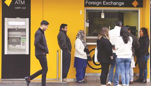 People queue outside a foreign exchange booth at a branch of the Commonwealth Bank of Australia in Sydney yesterday. The woes mounted for Australiau2019s biggest bank with an independent inquiry to be launched into its governance, culture and accountability after it was accused of breaching anti-money laundering legislation.