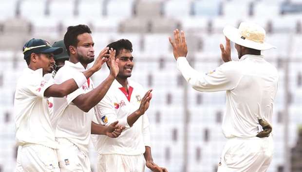 Bangladeshu2019s Shakib Al Hasan (second from left) celebrates the wicket of Australiau2019s Matt Renshaw on second day of the first Test in Dhaka yesterday. (AFP)