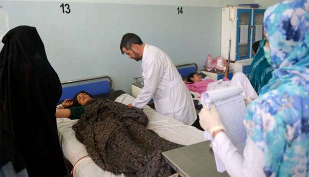 An injured Afghan woman receives treatment at a hospital following an airstrike in Herat