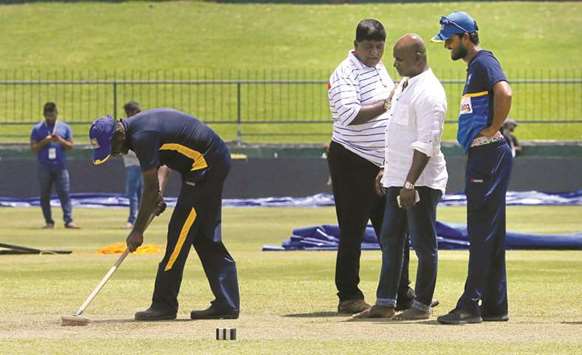 In this August 11, 2017, picture, Sri Lankau2019s Dinesh Chandimal (right) and chairman of selection committee Sanath Jayasuriya (second from right) inspect the pitch ahead of their final Test against India Pallekele, India. According to reports, the Sri Lankan selection committee, led by Jayasuriya, will step down after the current limited overs series against India. (Reuters)