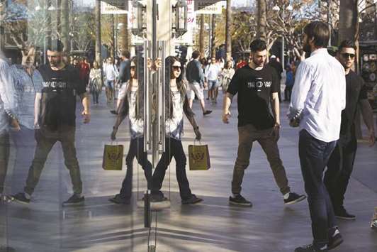 Shoppers are reflected in the window of a store at the Third Street Promenade in Santa Monica. US consumer confidence surged to a five-month high in August as households grew increasingly upbeat about the labour market while house prices rose further in June, suggesting a recent acceleration in consumer spending was likely to be sustained.