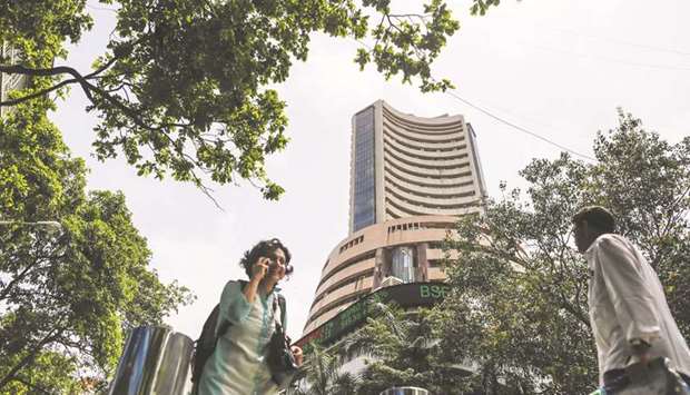Pedestrians walk past the Bombay Stock Exchange building in Mumbai. The Sensex closed down 362 points to 31,388.39 yesterday.