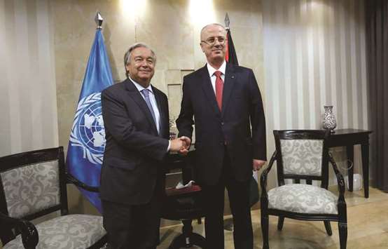 United Nations Secretary-General Antonio Guterres shakes hands with Palestinian Prime Minister Rami Hamdallah during their meeting in the West Bank city of Ramallah.