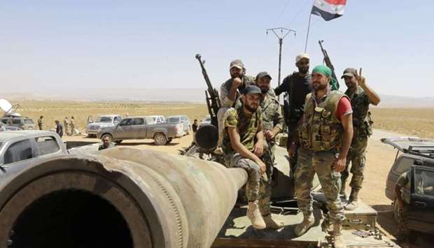 Syrian army fighters stand guard in the Qara area, in Syria's Qalamoun region, as members of the Islamic State (IS) group and their families are transported to Deir Ezzor under part of an unprecedented deal to end three years of jihadist presence on August 28, 2017.
