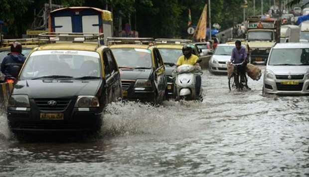 Commuters drive along a flooded road in Mumbai on Wednesday after heavy rains brought major flooding to the coastal city.