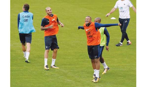 Franceu2019s Kylian Mbappe (right) is all smies as he takes part in a training session in Saint-Denis, France, yesterday. (Reuters)