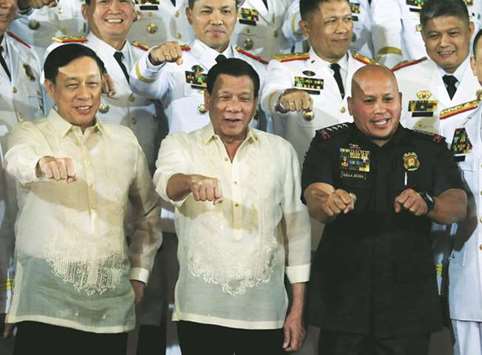 President Rodrigo Duterte with Philippine National Police (PNP) chief Ronald u201cBatou201d Dela Rosa (right) and Department of Interior and Local Government (DILG) undersecretary Catalino Cuy, gestures during the oath taking of PNP star rank officers, at the Malacanang Presidential Palace in Manila, yesterday.