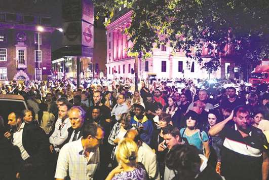 Commuters wait outside Euston Station late on Tuesday.