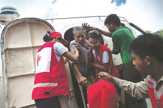 Members of Myanmaru2019s Red Cross help people fleeing a conflict area upon arriving in Sittwe jetty, in Rakhine state.