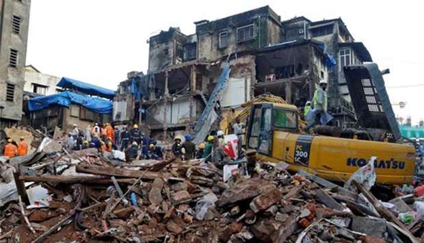 Firefighters and rescue workers search for survivors at the site of a collapsed building in Mumbai on Thursday.