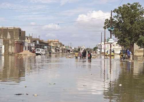 People wade through a flooded street after heavy rain in Karachi yesterday.