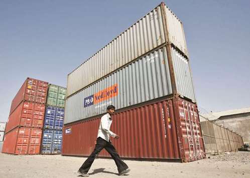 A worker walks past stacked containers at Thar Dry Port in Sanand in the western Indian state of Gujarat. The economic slowdown bodes ill as India u2013 a nation of 1.25bn u2013 tries to absorb tens of thousands of new jobseekers into the economy every month, Aditi Nayar, principal economist at rating firm ICRA, said yesterday.