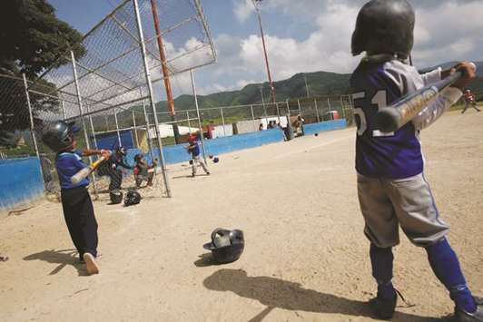 In this August 24, 2017, picture, children play at a baseball tournament in Caracas. (Reuters)
