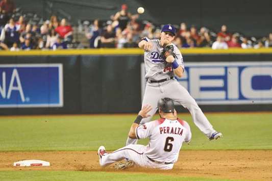 Los Angeles Dodgers centre fielder Enrique Hernandez (top) turns a double play on Arizona Diamondbacks right fielder David Peralta during the fifth inning of their MLB game at Chase Field in Phoenix, Arizona, on Wednesday. (USA TODAY Sports)