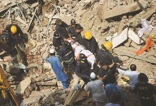 Firemen carry the body of a victim out of the debris of the collapsed building in Mumbai yesterday.