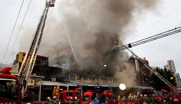 Firefighters operate at the fire site at Tokyo's Tsukiji fish market in Tokyo