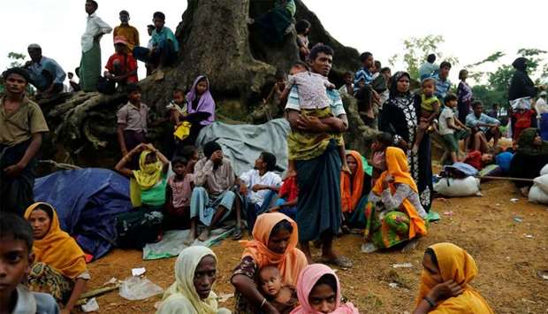 New Rohingya refugees sit near the Kutupalang makeshift refugee camp, in Coxu2019s Bazar