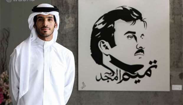 Qatari artist Ahmed al-Maadheed stands next to his painting of His Highness the Emir Sheikh Tamim bin Hamad al-Thani at a gallery in Doha.