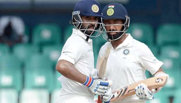 Indian batsmen Ajinkya Rahane (L) and teammate Cheteshwar Pujara run between the wickets during the first day of the second Test match against Sri Lanka at the Sinhalease Sports Club (SSC) Ground in Colombo yesterday.