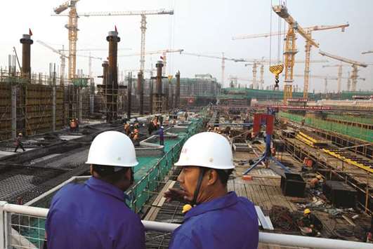 Workers survey the construction site of the terminal for the New Airport in Beijingu2019s southern Daxing district. Chinau2019s exports are seen rising 10.9% year-on-year in July, according to a median estimate from a poll of analysts.