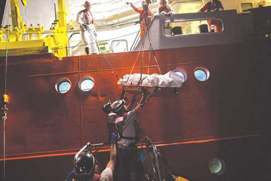 Members of the Aquarius rescue ship, run by non-governmental organisations SOS Mediterranee and Medecins Sans Frontieres (MSF, Doctors Without Borders), prepare yesterday to load a body bag of a migrant who died at sea onto a small vessel, before transferring it to a vessel of NGO Save the Children that will head to Italy, in the Mediterranean Sea, 20 nautic miles from the Libyan coast. The bodies of eight migrants have been found at sea off the coast of Libya by rescuers coming to the aid of four rubber dinghies, the Italian coast guard said on Tuesday.