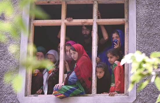 Kashmiri villagers watch the funeral procession of suspected rebel Suhail Ahmed Rather in the village of Tantraypora in Kulgam.