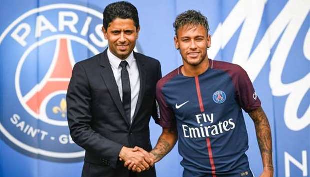 Brazilian superstar Neymar shakes hands with Paris Saint Germain's (PSG) Qatari president Nasser al-Khelaifi during a press conference at the Parc des Princes stadium in Paris on Friday.