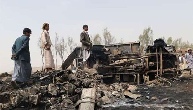 People stand at the site of a Saudi-led air strike on the outskirts of the northwestern Yemeni city of Saada on Friday.