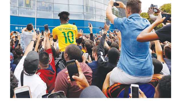 PSG fans take photos outside the Parc des Princes stadium during the presentation of Neymar Jr. in Paris.