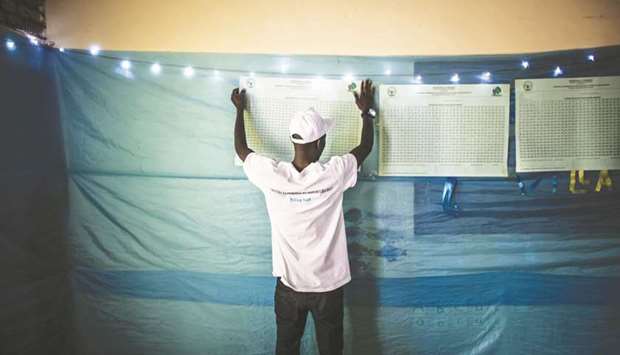 An electoral Commission official hangs a counting board at a polling station in Kigali at the beginning of the vote counting for the presidential elections.