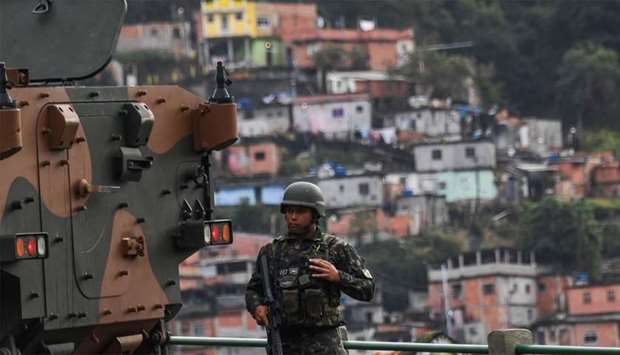 A soldier takes position at Morro do Macaco slum in Rio de Janeiro, Brazil, during a pre-dawn crackdown on crime gangs