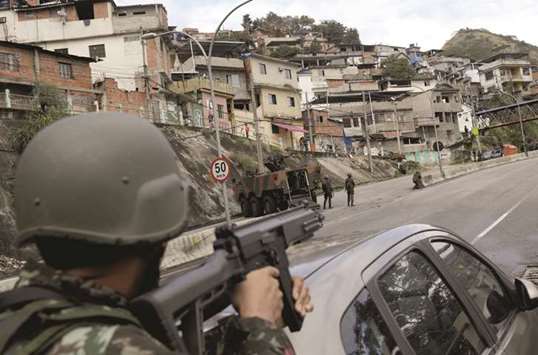 Armed Forces troops take up position during an operation against the organised crime in Lins slum complex in Rio de Janeiro.