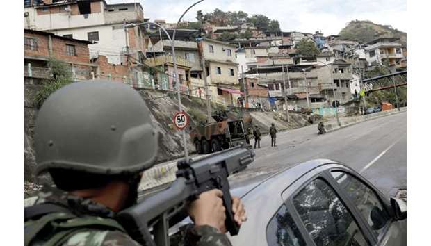 Armed Forces troops take up position during an operation against the organised crime in Lins slum  complex in Rio de Janeiro.