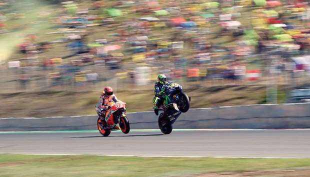 Repsol Honda rider Marc Marquez (left) and Movistar Yamaha rider Valentino Rossi do wheelies during the qualification round for the Czech MotoGP in Brno yesterday. (AFP)