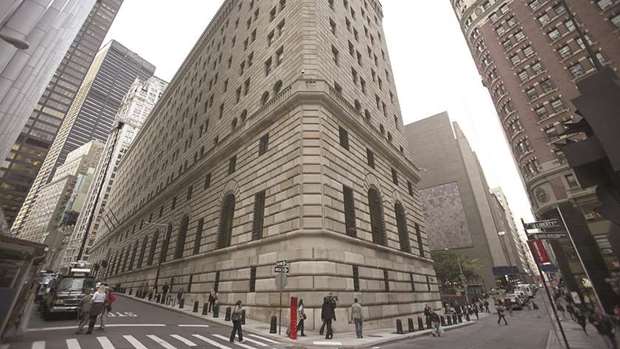 Pedestrians walk past the New York Federal Reserve building.