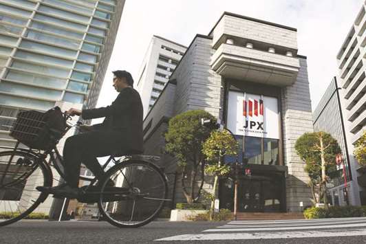 A man cycles past the Tokyo Stock Exchange. After handily beating the rest of Asia for much of the past five years, Japanese stocks are lagging behind in 2017.
