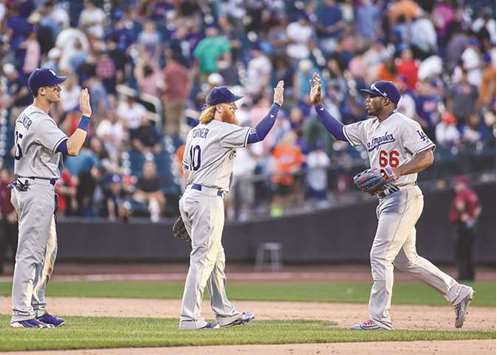 Los Angeles Dodgers first baseman Cody Bellinger (left) and third baseman Justin Turner (centre) celebrate with right fielder Yasiel Puig after their 7-4 victory over the New York Mets at Citi Field in New York on Saturday. (USA TODAY Sports)