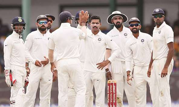 Indiau2019s Ravindra Jadeja (centre) celebrates with teammates after taking the wicket of Sri Lankau2019s Dimuth Karunaratne in Colombo yesterday. (Reuters)