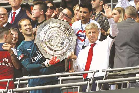 Arsenal manager Arsene Wenger (R) and goalkeeper Petr Cech (L) hold up their Community Shield trophy yesterday.