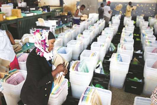 An election tallying officer stuffs voting material into ballot boxes, before they are transported to different polling stations in the Kibra Constituency, at a tallying centre in Nairobi.