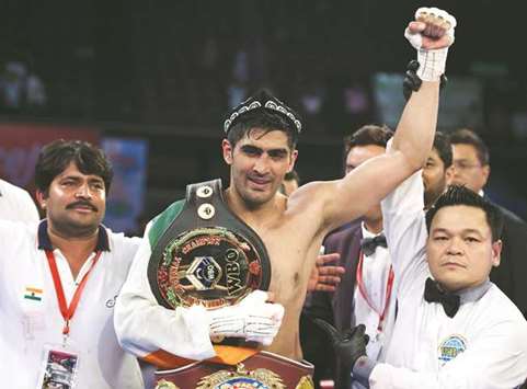 Indian boxer and WBO Asia-Pacific Super Middleweight champion Vijender Singh (centre) celebrates after winning the double title bout against Chinau2019s Zulpikar Maimaitiali in Mumbai on Saturday. (AFP)