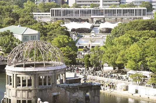 People are seen at the Peace Memorial Park with the Atomic Bomb Dome in the front, at a ceremony in Hiroshima, western Japan, on the 72nd anniversary of the atomic bombing of the city.
