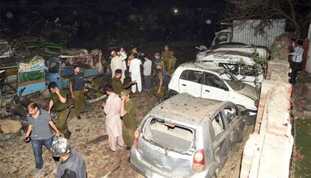 Pakistani security officials inspect the site of an explosion in Lahore on Monday.