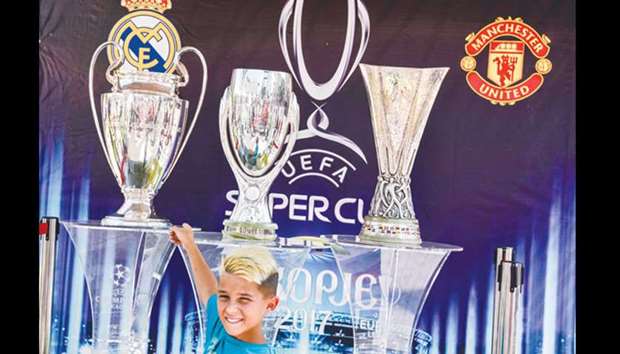 A child poses in front of trophies at the UEFA Super Cup fan zone in Skopje yesterday ahead of UEFA Super Cup match between Real Madrid and Manchester United.