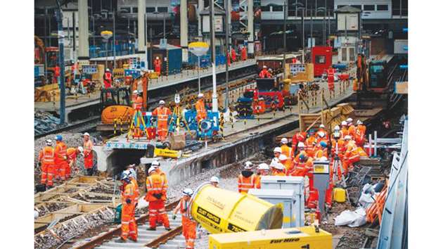 Construction workers lay rail tracks as Network Rail commenced major work to upgrade Waterloo rail station in central London.